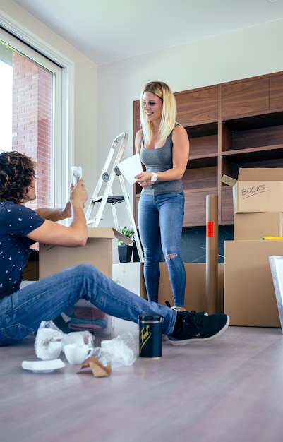 Couple unpacking moving boxes in their new house