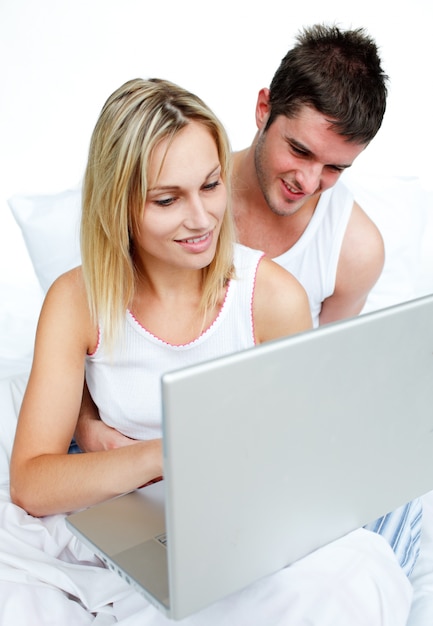 Couple using a laptop in bed