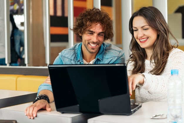 Couple using the laptop in the restaurant while take a lunch.