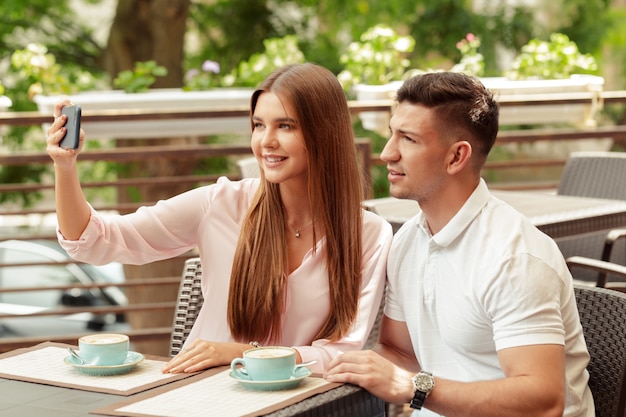 Couple using mobile phone in cafe