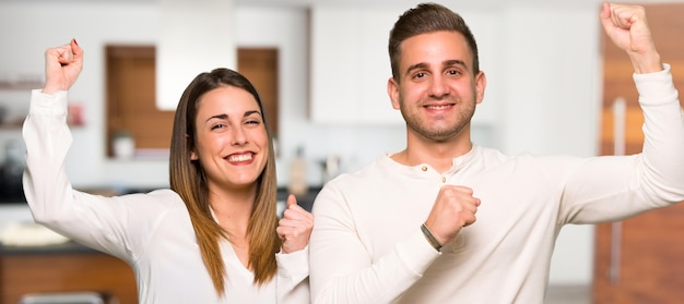 Couple in valentine day celebrating a victory in a house