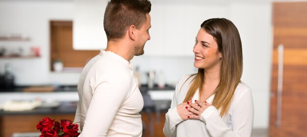 Couple in valentine day with flowers in a house