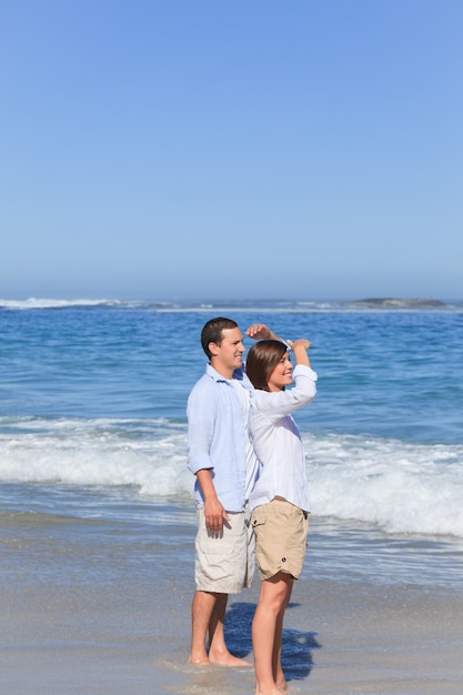 Couple walking on the beach under the sun