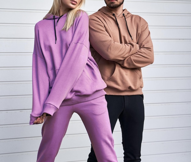 Photo couple wearing casual street outfit man standing in brown suede sweater woman wears pink violet fleece hoodie and pants