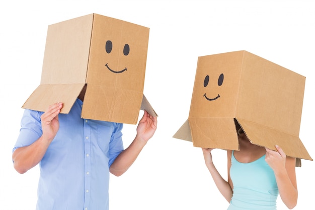 Photo couple wearing emoticon face boxes on their heads