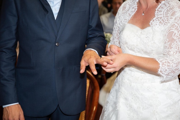 Couple wearing wedding ring at wedding day with closeup bride groom hands