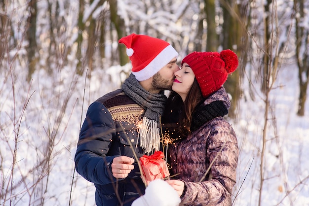 Couple with bengals and gift in winter forest