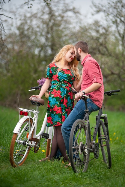 Couple with bicycles loving in spring garden