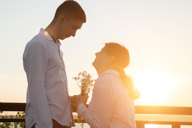 Couple with disabilities stands together at back sunset