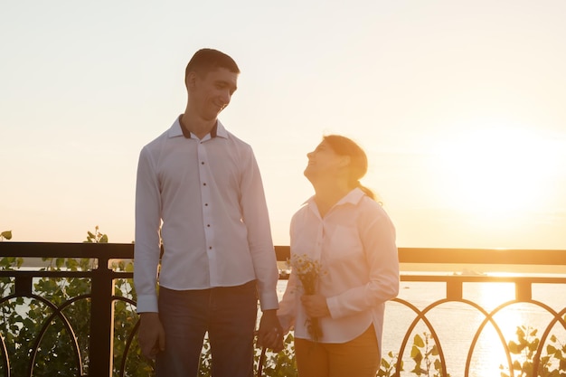 Couple with disabilities stands together at back sunset