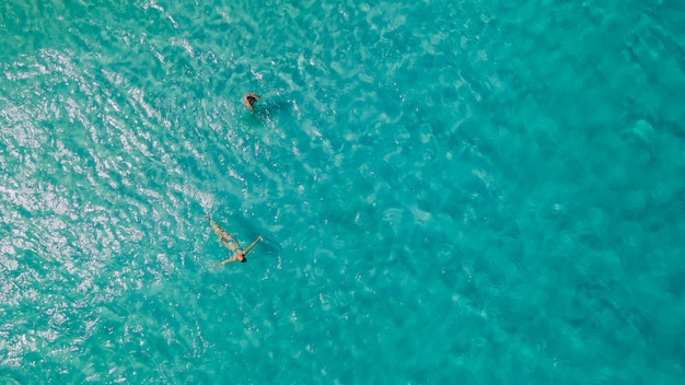 Couple of woman floating in clear blue ocean. Aerial view. High quality photo