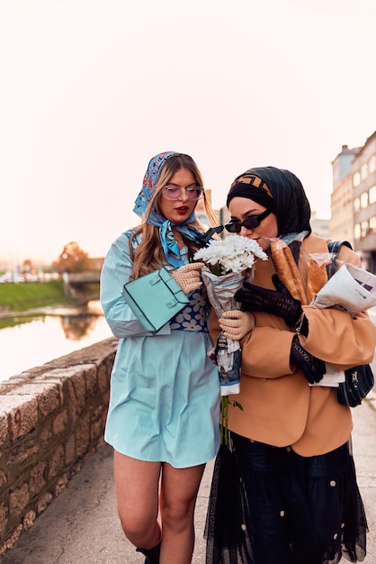 Couple woman one wearing a hijab and a modern yet traditional dress and the other in a blue dress an