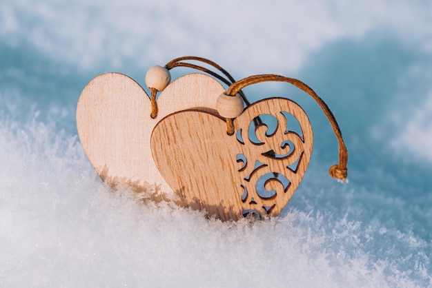 Couple of wooden hearts in cold frosty morning snow valentines day greeting card symbol of love and ...