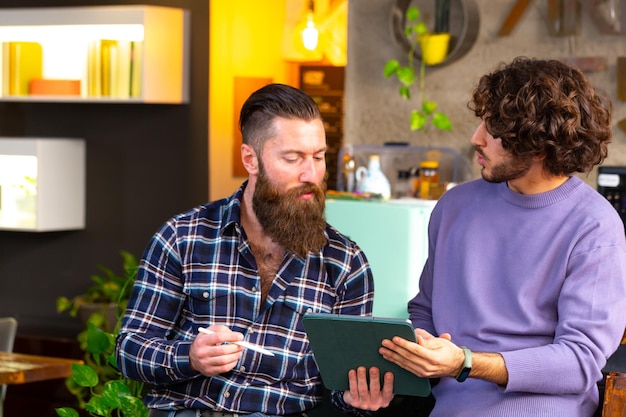 Couple of young guys discussing work results on tablet