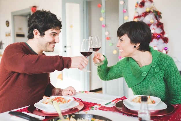 Couple of young handsome man and woman sitting on a table