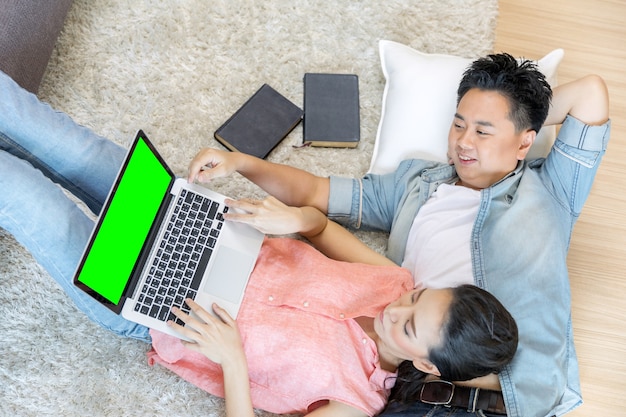 Couples lying down using laptop