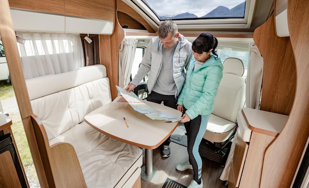 Couples in RV Camper looking at the local map for the trip. Family vacation travel, holiday trip in motorhome, Caravan car Vacation.