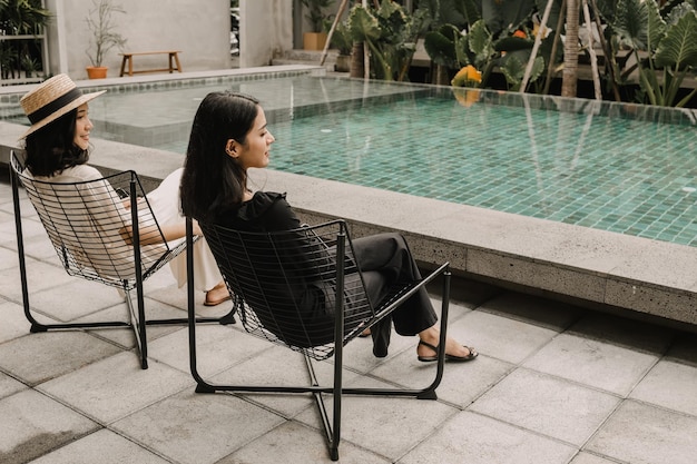 Couples women sit near swimming pool