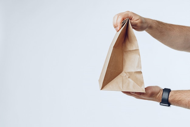 Courier hands giving packed food delivery close up