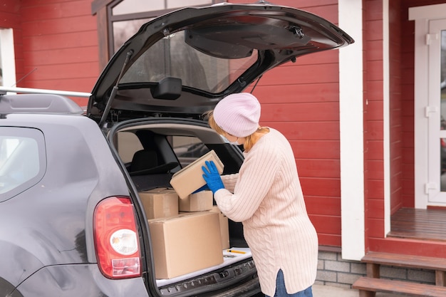 The courier is holding a cardboard box of medical rubber gloves