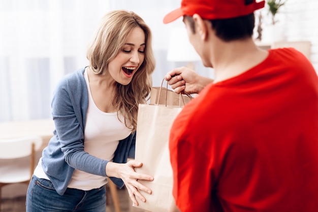 Courier in Orange Clothes Gives Package Woman.