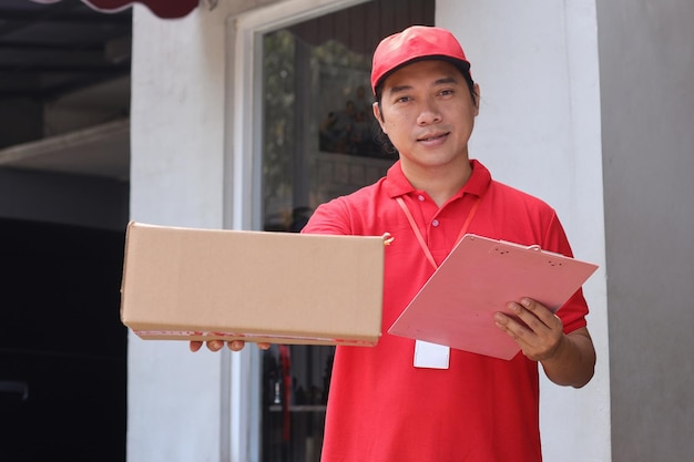 Courier in red uniform holds package box and document