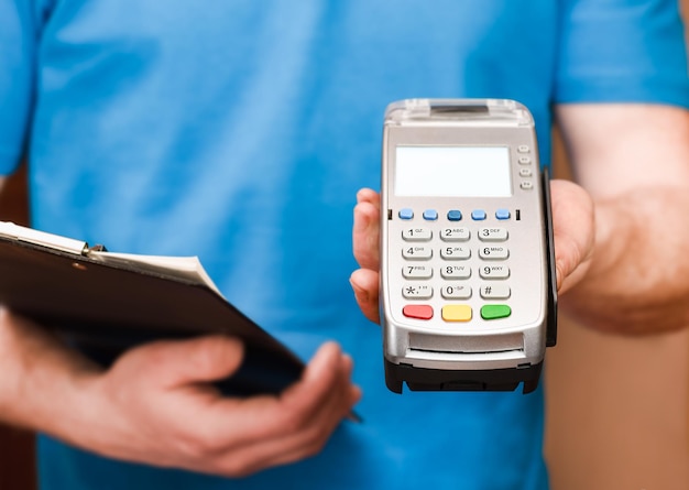 Courier stretches out his hand with a terminal for payment