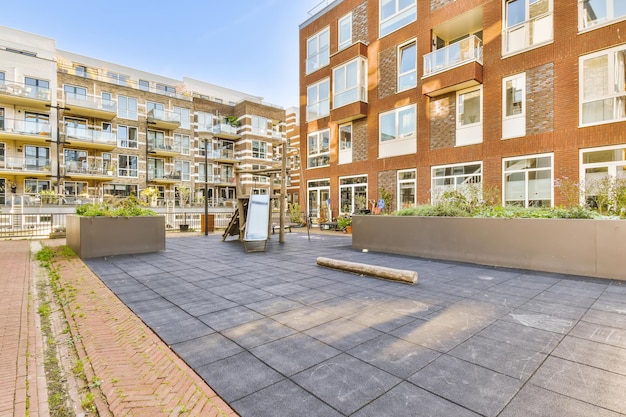 A courtyard in front of a large brick apartment building