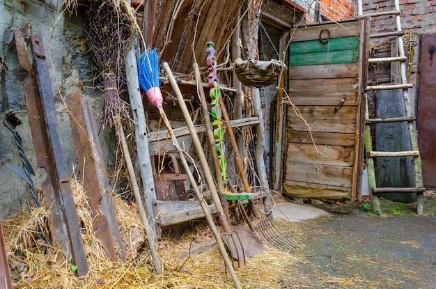 The courtyard of an old house in the village. Tools in the yard.