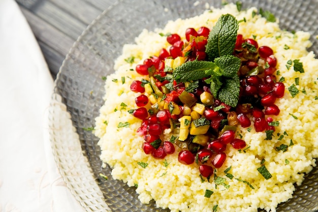 Couscous salad with pomegranate and mint leaves