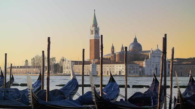 Covered gondolas swaying on water against a beautiful venice view