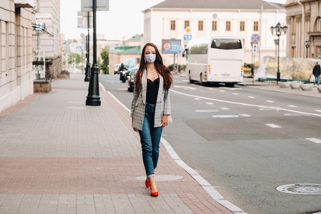 Covid-19 and Air pollution pm2.5 concept. Pandemic, portrait of a young woman wearing protective mask on street. Concept health and safety.