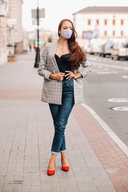 Covid-19 and Air pollution pm2.5 concept. Pandemic, portrait of a young woman wearing protective mask on street. Concept health and safety.