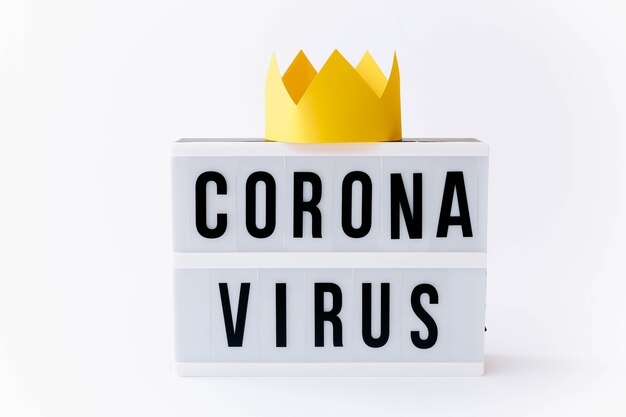 Covid 19, Corona virus text on display in lightbox with crown on it, light table.