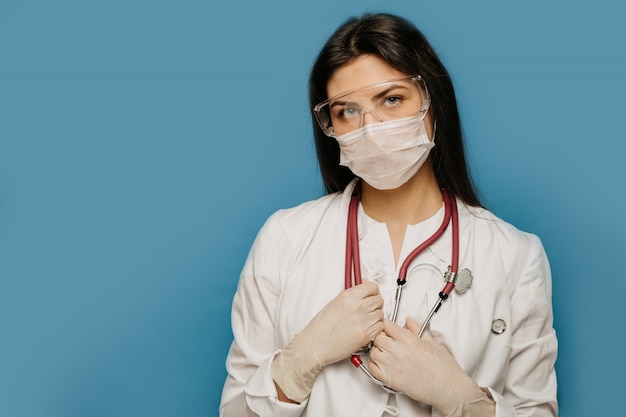 COVID-19 Coronavirus pandemic serious doctor close up portrait wearing surgical mask