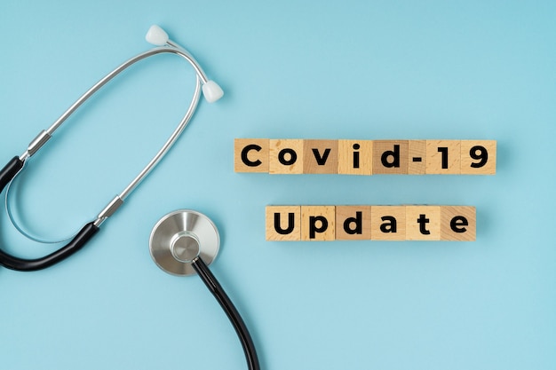 COVID-19 UPDATE text with stethoscope on blue Corona virus concept.