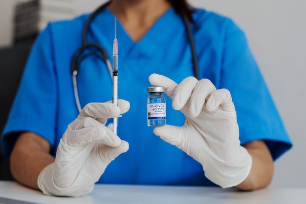 COVID-19 vaccine in researcher hands, female doctor holds syringe and bottle with vaccine for coronavirus cure