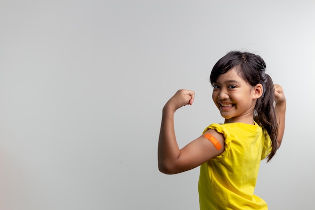 COVID 19 Vaccines for Kids concept Studio a portrait of an adorable Asian girl after getting his first dose of vaccine Immune Safe Available Back to school