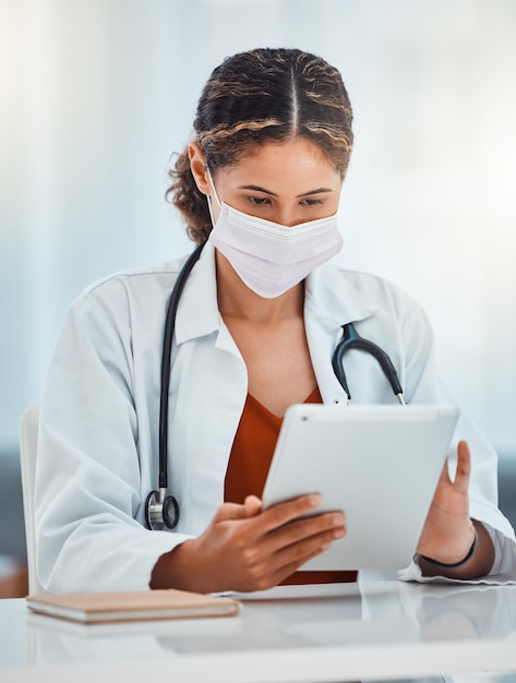 Covid doctor and woman with tablet working on covid 19 corona virus or medical healthcare research for pandemic solution Digital mobile tech telehealth and hospital employee with safety face mask