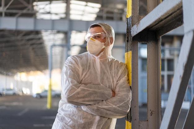 COVID19 coronavirus doctor standing hospital parking dressed white protective overalls hazmat suit