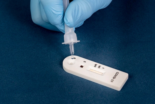 Covid19 rapid test with person dripping the reagent