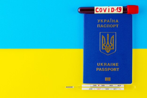 COVID19 and travel concept on the Ukrainian flag Ukrainian biometric passport on a yellowblue flag