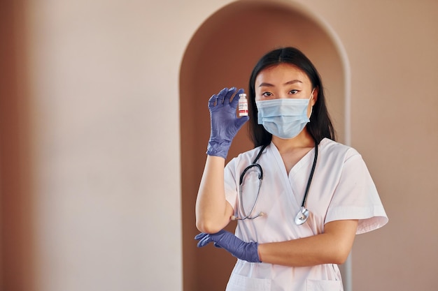 COVID19 vaccine Young serious asian woman standing indoors