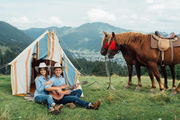 Cowboy and cowgirl in the mountains with their horses