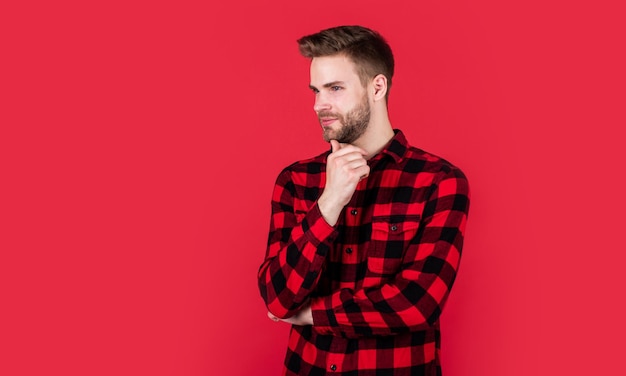 Cowboy style cheerful and stylish handsome man on red background indoor portrait of sexy european businessman confident and calm handsome casual man standing with beard and bristle copy space