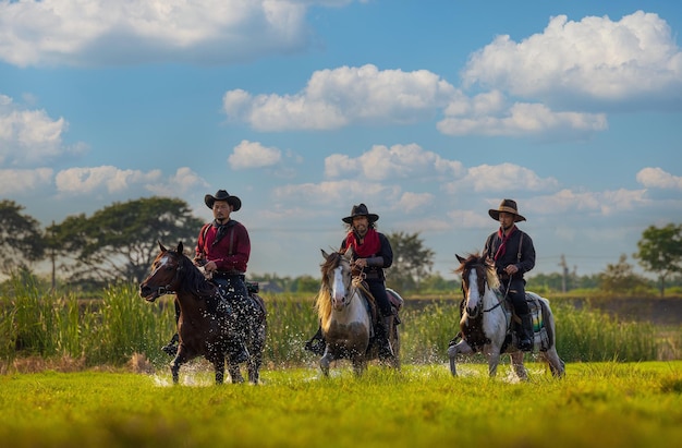 Cowboys riding horses beside the river and lifestyle with natural light background