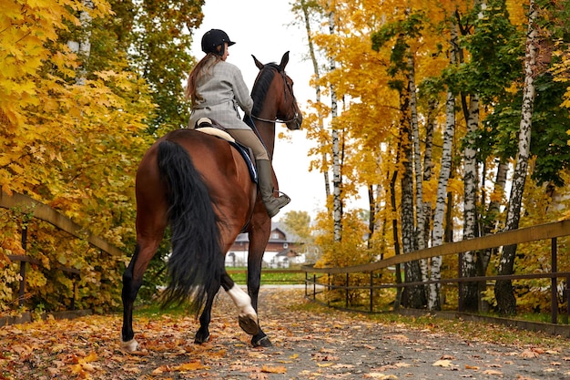 Cowgirl in a cowboy hat rides a horse on the background of the forest Motion blur effect