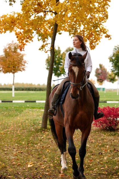 Cowgirl in a cowboy hat rides a horse on the background of the forest Motion blur effect