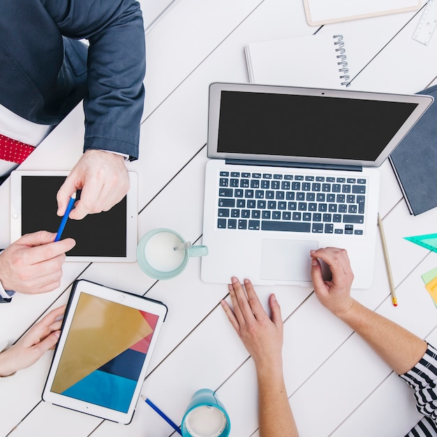 Coworkers using devices at desk