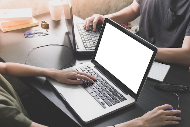 Coworkers working on the same desk, they are using a laptop with blank screen, Start up bu